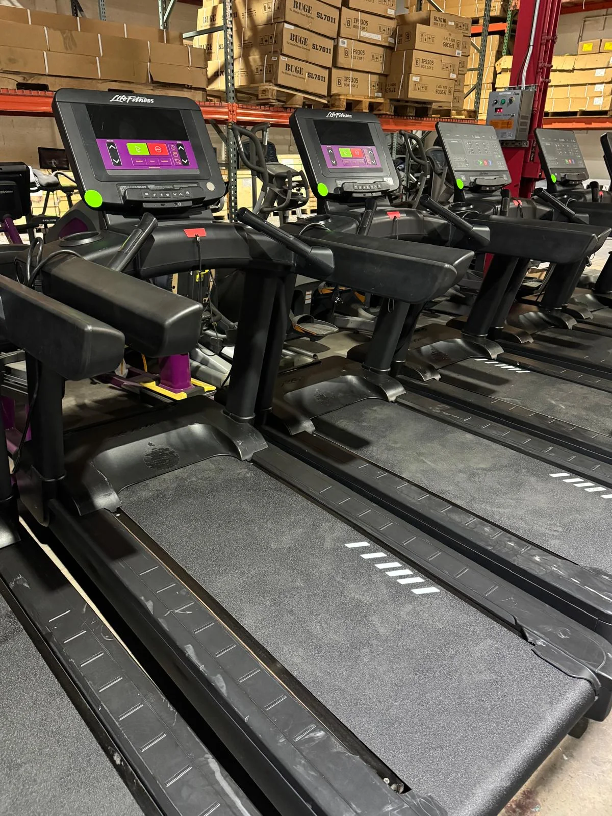 Pre-owned Life Fitness Integrity treadmills with C Console and current purple overlays in the BUGE warehouse